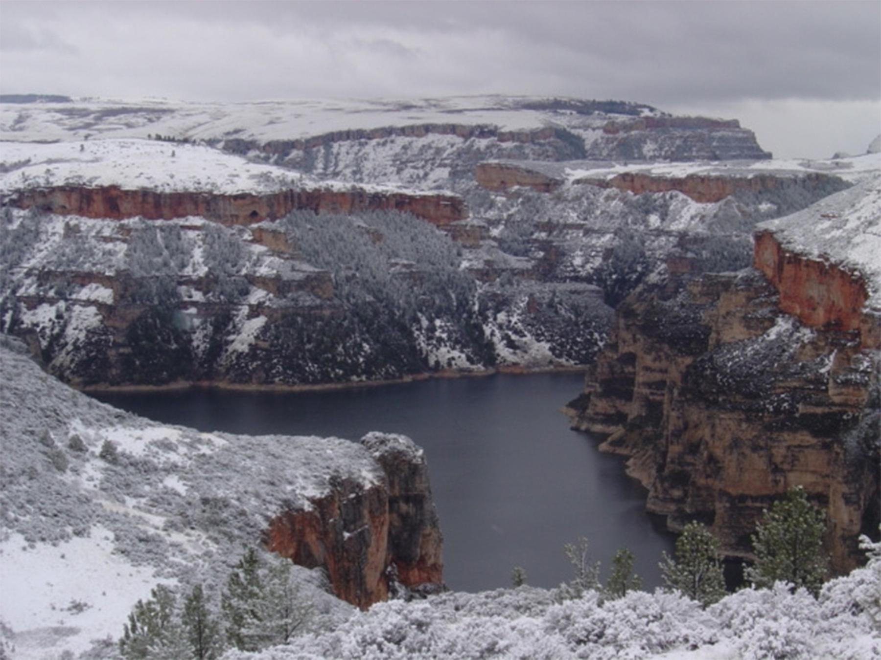 In March 1891, while awaiting permission to survey a route for the  Burlington Railroad through the Crow Reservation in Montana, Gillette and a small crew decided to explore the canyon of the Bighorn River, shown here after a light snow. The canyon crosses the Wyoming-Montana border; its sheer cliffs rise in some places 2,500 feet above the water. In Gillete’s time the river, now dammed, was swift flowing and, when he explored the canyon, frozen—the men walked the length of the canyon on ice in below-zero t