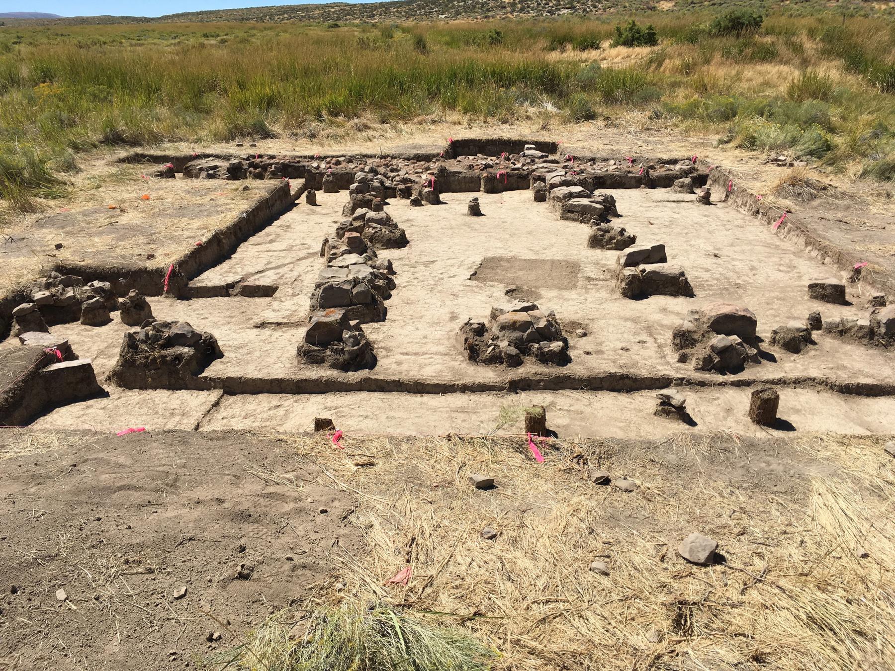 view looking down on excavated area with what appear to be multiple remains of roof supports