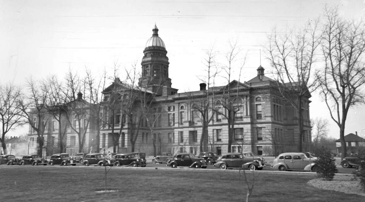 Another pair of wings, east and west, shown here, was added to the building beginning in 1917, bringing it to its present size. Judging from the cars, this photo dates from around 1940. J.E. Stimson photo, Wyoming State Archives.