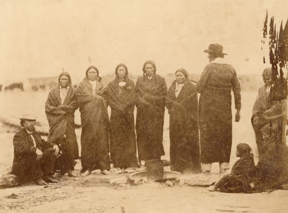 Sicangu (Brule) Lakota Sioux and Oohenonpa (Two Kettle) Lakota Sioux men and women and an interpreter gathered at Fort Laramie for the 1868 treaty signing. From left to right: Leon Palladay (interpreter), Fast Bear, Spotted Tail, White Eyes, Swift Bear, Whirlwind Soldier, Long Mandan, unidentified child, The Mule's wife, Big Partisan's daughter. Sherman collection of Gardner photographs; NMAI.