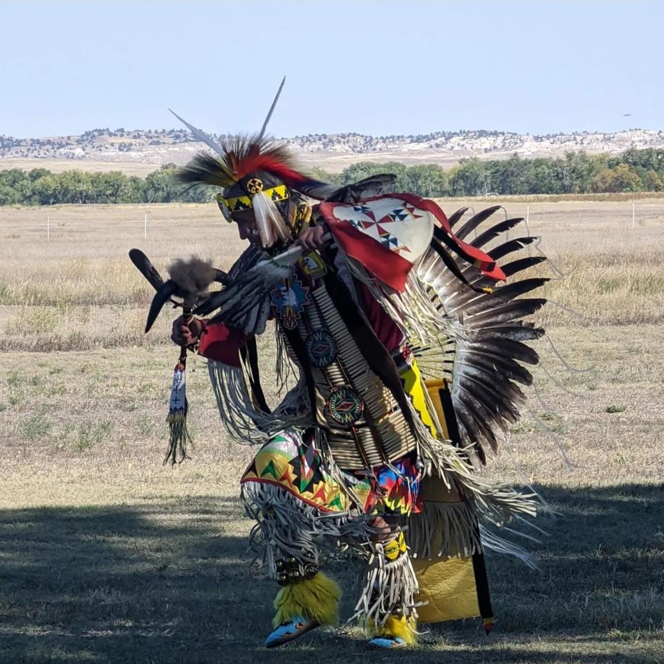 a vividly costumed Indigenous dancer in action