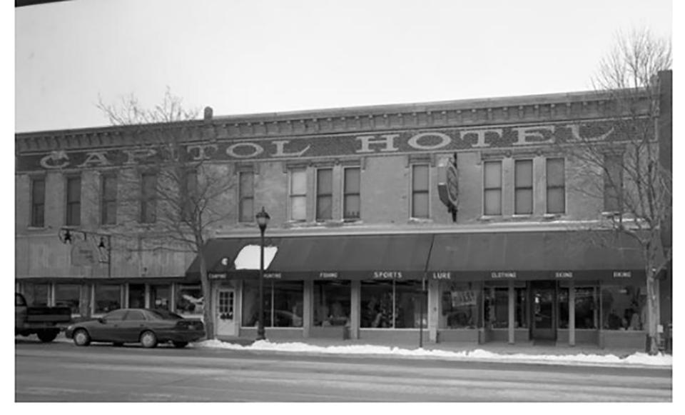 Brick building along a main street, with sign at top: "Capitol Hotel"