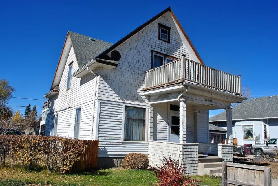 two story white house with a porch deck over the front door