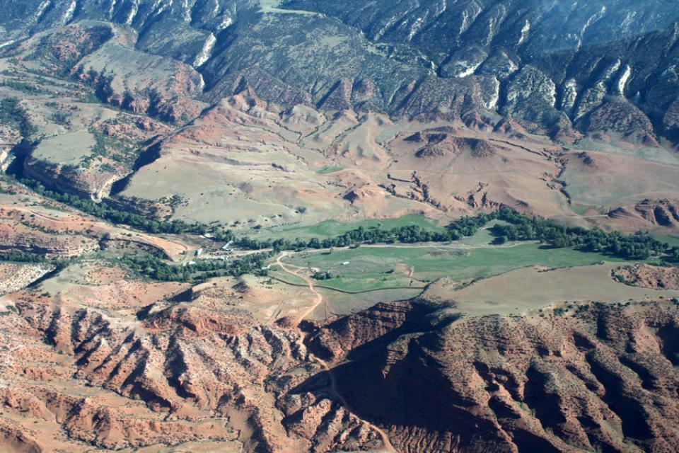 The Dull Knife battlefield from the air. The Cheyenne village of 153 lodges was along the creek in the middle of the photo. Soldiers advanced from the east, at right. Shoshone warriors fired down onto the village from the bluff in the foreground. Cheyenne warriors leapt up from the ravine north of the creek, at center, to stop the cavalry charge. Cheyenne noncombatants escaped up the deep ravine angling from the left toward the upper center. Tom Rea photo.