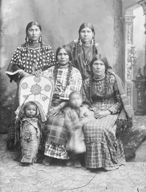 Kate Enos at top left, almost certainly at the same sitting as in the first photo. With her are her sisters, Louisa Enos Wesaw, Mary Enos Rabbittail, and Emma Enos Lewis. The baby in the cradle board is thought to be Antoine Weed, and the little girl standing, Sousanna Weed. Both are Mary Enos Rabbittail’s children. American Heritage Center via Sweetwater County Historical Museum.