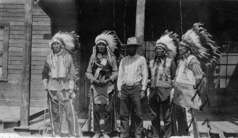 The Farlow family involved itself with Wind River Indians and show business for more than three decades. Shown here, Jule Farlow, center, with, left to right, Arapaho actors Goes-in-Lodge, John Yellow Dress, John Crook and Tom Crispin on the set of "Big Trail," 1930. Lander Pioneer Museum.