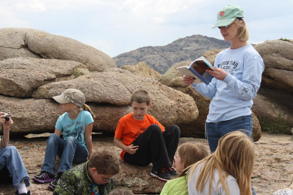 Teacher Debbie LaChance reads from Oregon Trail diaries to fourth graders from Oregon Trail Elementary School, Casper, Wyo. on the top of Independence Rock, May 2013. Tom Rea photo.