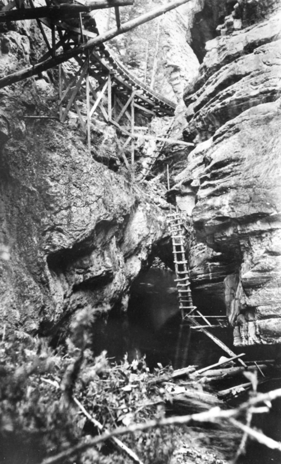 In the steepest parts of the canyon, the flume was perched on trestles or hung from steel cables anchored to eye bolts drilled into sheer rock walls. Wyoming State Archives.