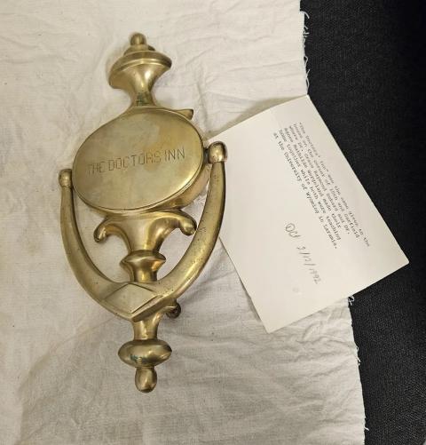 brass door knocker engraved with the words, "The Doctors Inn"